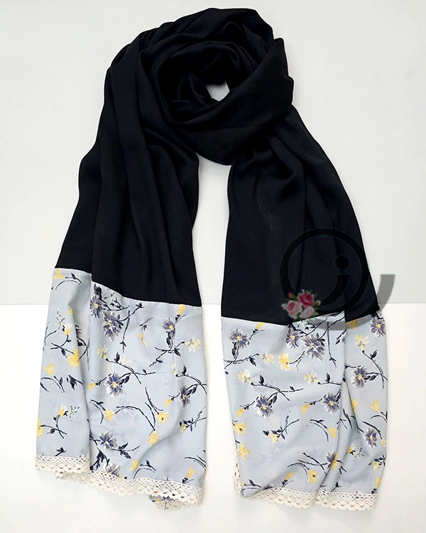 شال مشکی با حاشیه طوسی گلدار روی میز